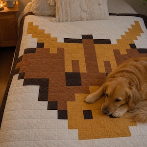 Puede incluir: Una colcha que presenta un gran gráfico pixelado de una cabeza de vaca Highland en tonos marrón, bronceado y marrón oscuro sobre un fondo color crema. El diseño está compuesto por bloques de tela cuadrados, creando un aspecto geométrico.