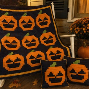 Peut inclure: Une courtepointe et deux coussins carrés assortis présentant un motif de citrouille pixelisé. Le design se compose de citrouilles orange avec des traits du visage bleu foncé et des tiges vertes sur un fond bleu foncé avec une bordure jaune.
