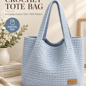 May include: A light blue crochet tote bag with two handles and a small rectangular brown tag in the bottom corner that reads Handmade. The text CROCHET TOTE BAG, Everyday Cotton Tote, PDF Pattern, and a blue circle with DIGITAL PDF are visible.