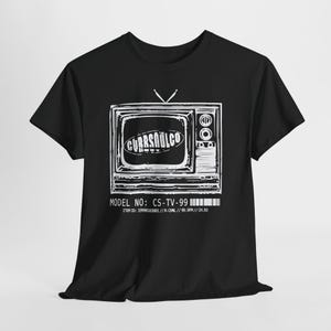 May include: A black short-sleeved t-shirt featuring a white graphic of a vintage television set. The screen displays the text CURRSOULCO. Below the television, the text reads MODEL NO: CS-TV-99, ITEM ID: 19990193981 // R-CHNL // 99.9FM // CH.03.