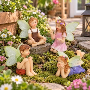Puede incluir: Cuatro figuras de hadas con alas translúcidas en un jardín. Una sentada sobre una roca con peto marrón, una arrodillada con vestido rosa y corona floral, una sentada con camiseta verde y pantalón rojo, y una tumbada con vestido morado.