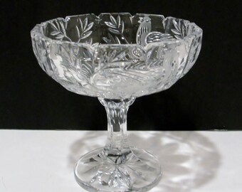 Plato de pedestal de cristal tallado con pájaros y ramas grabados dentro del diseño