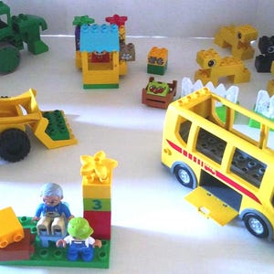 Jeu de construction LEGO DUPLO.  Briques vintage comprenant des briques et des véhicules de la gare routière et de la ferme Lego.