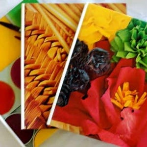 May include: A collection of three decorative art pieces with vibrant imagery. One features a yellow and red color scheme with circular patterns, another showcases a woven texture, and the third displays a floral arrangement with red petals and green accents.