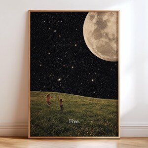 May include: A framed wall art print featuring a dark night sky filled with stars and a large moon above a grassy field. Two small figures are running through the green grass. The word Free. is printed in white text at the bottom of the image.