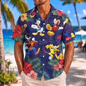 May include: A short-sleeve button-down shirt in dark blue featuring a tropical print with red and yellow hibiscus flowers, green palm leaves, and cartoon characters including Mickey Mouse, Donald Duck, Goofy, and Pluto in a colorful graphic pattern.