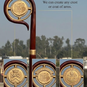 Peut inclure: Une crosse en bois avec une finition brun foncé polie et une tête circulaire dorée. La tête présente un médaillon central doré avec divers écussons et armoiries. Le texte indique : PERSONALISATION EXAMPLES: We can create any crest or coat of arms.