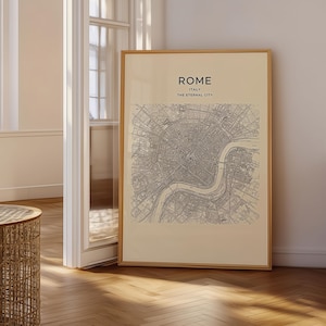 Puede incluir: Una lámina de arte enmarcada que muestra un mapa detallado de líneas negras de Roma, Italia. El texto en la parte superior dice ROME, ITALY, THE ETERNAL CITY. La impresión tiene un fondo beige claro y está en un marco de madera fina.
