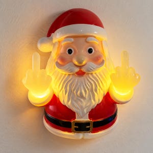 May include: A wall-mounted Santa Claus light fitting featuring a glossy red and white finish. The figure wears a red hat and suit with a black belt, and both hands are raised with the middle fingers extended. The hands emit a warm yellow glow.