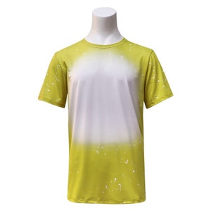 May include: A yellow short-sleeved t-shirt with a white splatter paint design. The shirt has a gradient effect, fading from white to yellow.