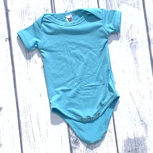 May include: A light blue baby onesie with short sleeves and snap closures. The onesie is made of a soft, comfortable fabric.