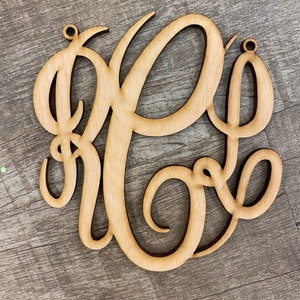 May include: A wooden monogram with the letters "R.E." in a cursive script. The letters are cut out of a single piece of wood and have a natural wood finish.