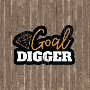 May include: A black and gold graphic with the words "Goal Digger" in white and gold lettering. A diamond graphic is on the left side. The background is a wood grain pattern.