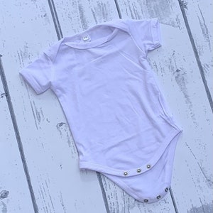 May include: White baby onesie with short sleeves and snap closures.