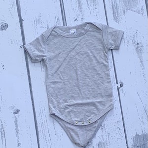 May include: A heather gray short-sleeved bodysuit with a snap closure. The bodysuit is made of a soft, comfortable fabric.