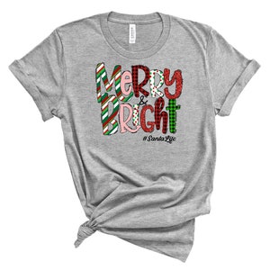 May include: A gray t-shirt with a festive Christmas design that says "Merry & Bright" with a red, green, and white plaid pattern. The text also includes the hashtag "#SantaLife".