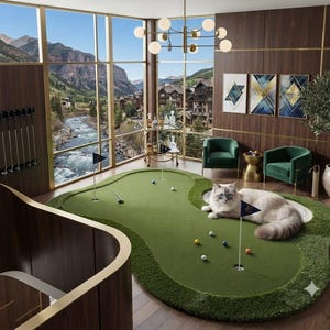 Puede incluir: Una alfombra de putting green para interiores con superficie de césped sintético, dos mástiles con bandera y varias pelotas de golf. Un gato de pelo largo con pelaje crema y gris descansa sobre el green. El set incluye un putter en una habitación con paneles de madera.