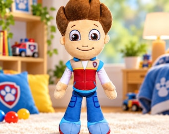 May include: A plush toy of a boy character with brown hair, wearing a red vest with blue and white accents over a white long-sleeved shirt, and blue trousers. The character has large brown eyes, a small nose, and a smiling mouth.