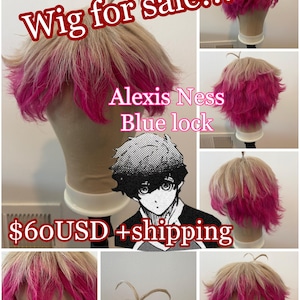 May include: A short, layered wig featuring a light beige base colour with vibrant pink highlights on the tips. The wig is styled with a small, upright tuft of hair at the crown. Text on the image reads: Wig for sale!!! Alexis Ness Blue lock $60USD +shipping.
