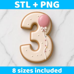 Op de afbeelding: Een koekje in de vorm van het cijfer 3 met crèmekleurig glazuur, versierd met een roze ballon, een witte strik en kleine gekleurde stippen. De tekst STL + PNG en 8 sizes included is zichtbaar boven- en onderaan het beeldkader.