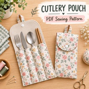 Pode incluir: Duas bolsas de tecido para talheres com estampa floral de flores rosas e amarelas em fundo creme. Uma bolsa está aberta, contendo um garfo, faca, colher de metal e hashis de madeira. Ambas as bolsas possuem fecho de pressão e alça.