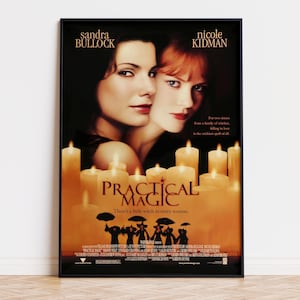 May include: A framed movie poster for Practical Magic featuring Sandra Bullock and Nicole Kidman. The poster displays the film title, cast names, and a silhouette of figures holding umbrellas above a collection of glowing orange candles.