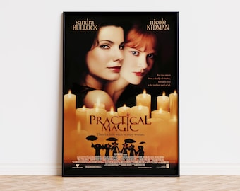 Puede incluir: Un póster de película enmarcado de Practical Magic con Sandra Bullock y Nicole Kidman. El cartel muestra el título de la película, los nombres del reparto y una silueta de figuras con paraguas sobre velas de color naranja brillante.