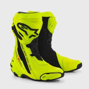 Peut inclure: Une paire de bottes de moto montantes en jaune fluo et noir. Les bottes présentent un logo Alpinestars noir proéminent sur le côté, des panneaux texturés, un curseur d'orteil renforcé et le texte Supertech R imprimé le long de la fermeture.