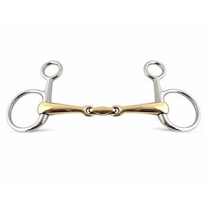 Può includere: Un imboccatura per cavallo con un pezzo centrale in metallo dorato dotato di snodo centrale e anelli laterali in metallo argentato. Gli anelli laterali sono composti da un anello inferiore grande e uno superiore più piccolo, uniti da una barra.