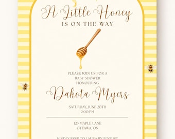 May include: A baby shower invitation card with a yellow and white striped border, a yellow bow at the top, and bee illustrations. The text reads: A Little Honey IS ON THE WAY, PLEASE JOIN US FOR A BABY SHOWER HONOURING Dakota Myers, SATURDAY, JUNE 20TH, 2:00 PM, 123 MAPLE LANE, OTTAWA, ON, KINDLY RSVP TO LAURA BY JUNE 1ST, Registered At BABYSTORE.