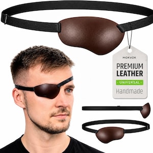 May include: A brown leather eye patch with a black elastic strap and an adjustable metal slider. A white product tag is attached, featuring the text MOKVOK, PREMIUM LEATHER, UNIVERSAL, and Handmade. The patch is shown worn and from multiple angles.