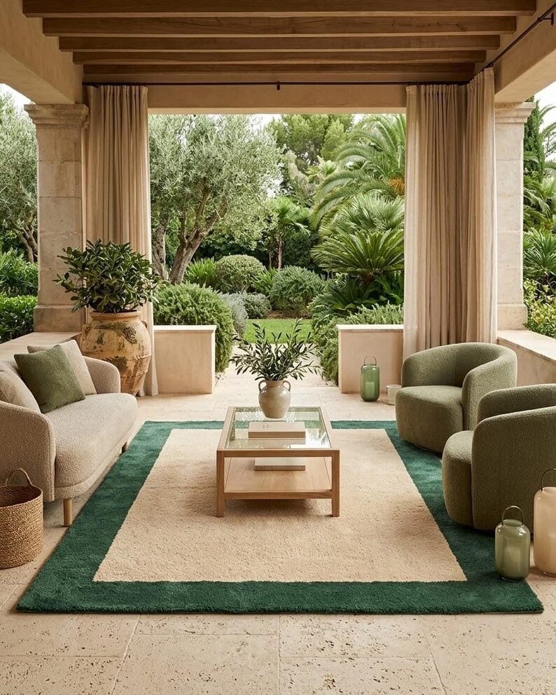 Puede incluir: Un conjunto de sala de estar con un sof&aacute; beige con un coj&iacute;n verde, dos sillones verdes y una mesa de centro rectangular de madera con tapa de cristal. Una alfombra rectangular grande con centro beige y borde verde oscuro en el suelo.