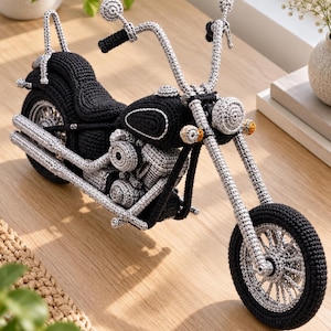 Peut inclure: Un modèle de moto en crochet fait main avec une selle, un cadre et des pneus noirs, contrastant avec des détails en fil gris clair sur le guidon, le moteur, les pots d'échappement et les rayons des roues. Inclut un phare rond et des clignotants orange.