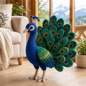 Könnte beinhalten: Eine handgefertigte Häkel-Pfauenfigur mit leuchtend blauem Hals und Kopf, einem grünen Flügel und einem großen, aufgefächerten Schwanz. Die Schwanzfedern sind mit kreisförmigen Mustern in Grün-, Gelb- und Blautönen verziert. Sie hat hellbeige Beine.