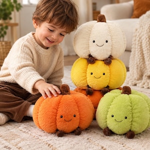 Peut inclure: Un ensemble de quatre citrouilles en peluche avec une texture douce et duveteuse et des visages souriants brodés. Les citrouilles sont de couleur crème, jaune, orange et vert clair, chacune avec une petite tige et des pieds marron.