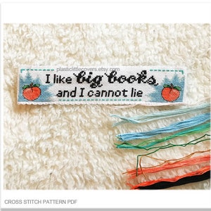 May include: Cross stitch pattern PDF for a bookmark with the text "I like big books and I cannot lie" and two peach illustrations.