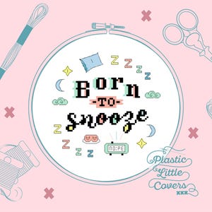 以下が含まれることがあります： ピンク色のグラフィックで、「Born to Snooze」の文字がクロスステッチ風に描かれ、睡眠をテーマにしたアイコンで囲まれています。刺繍糸、ハサミ、「Plastic Little Covers」の文字が含まれています。