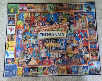 Könnte beinhalten: Ein rechteckiges Puzzle mit einer farbenfrohen Collage aus verschiedenen Broadway-Musical-Postern und Szenen. Der zentrale Text lautet Broadway THE MUSICALS in einer Schriftart im Stil eines Festzeltes. Das Bild besteht aus vielen kleinen Szenen.