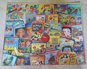 Könnte beinhalten: Ein rechteckiges Puzzle mit einer Collage aus alten Metall-Brotdosen mit verschiedenen Popkultur-Figuren, darunter Batman, Yogi Bear, Peanuts, Betty Boop, Wonder Woman und der Pink Panther, um eine School Days-Schultafel herum.