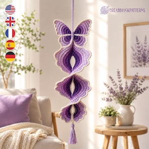 May include: A hanging crochet decoration featuring a butterfly at the top, transitioning into a spiraling, multi-layered purple and lavender design with a cream-colored border. The piece ends with a small purple tassel hanging from the bottom.
