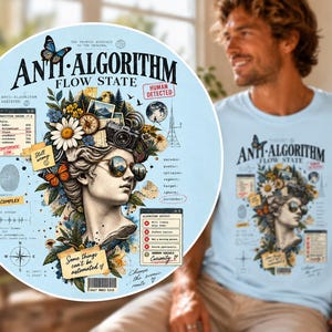 May include: A light blue t-shirt featuring a graphic print of a classical statue head wearing sunglasses, surrounded by flowers, a camera, butterflies, a compass, and various technical text elements including "ANTI-ALGORITHM FLOW STATE".