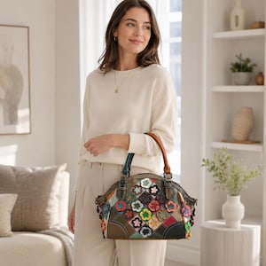 May include: A dome-shaped handbag featuring a patchwork design of multi-colored leather flower appliqués in shades of red, yellow, green, blue, and pink. The bag has a dark leather base, two sturdy handles, and metallic hardware accents.