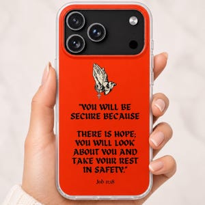 May include: A bright orange smartphone case featuring a graphic of praying hands with a cross pendant. The text reads: "YOU WILL BE SECURE BECAUSE THERE IS HOPE; YOU WILL LOOK ABOUT YOU AND TAKE YOUR REST IN SAFETY." The citation "Job 11:18" is printed below.