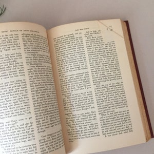 May include: A close-up of an open book with a brown leather cover. The pages are yellowed with age and the text is printed in black ink. The book is titled "The Red Pony" and is part of a series called "Short Novels of John Steinbeck".