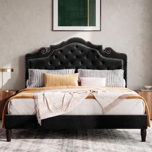 May include: A black upholstered bed frame featuring a tall, arched headboard with button tufting and silver nailhead trim. The bed is dressed with white sheets, a mustard yellow blanket, a patterned throw, and several striped and solid pillows.