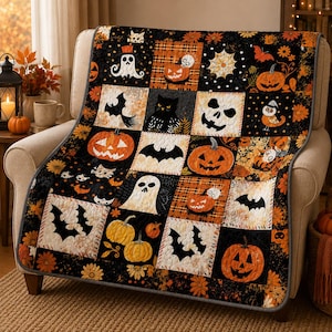 May include: A quilted throw blanket featuring a patchwork design with Halloween motifs including orange pumpkins, black cats, white ghosts, bats, spider webs, and skulls on a black and orange background with floral accents and a grey border.