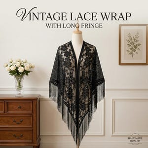 May include: A black lace wrap featuring a floral pattern and long fringe trim. The text VINTAGE LACE WRAP WITH LONG FRINGE is displayed at the top, and the text HANDMADE QUALITY is displayed in the bottom right corner of the image.