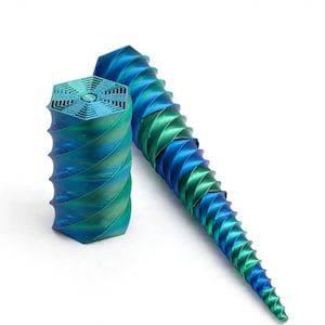 May include: Two 3D printed objects with a metallic iridescent finish that shifts between blue and green. One object is a short hexagonal cylinder with a geometric grid top, and the other is a long, slender, spiraling cone-shaped sculpture.