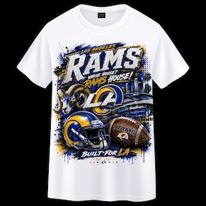 May include: A white short-sleeve t-shirt featuring a graphic print of the Los Angeles Rams. The design includes a ram head, a football helmet, a football, SoFi Stadium, and the text: LOS ANGELES RAMS, WHOSE HOUSE? RAMS HOUSE!, BUILT FOR LA.