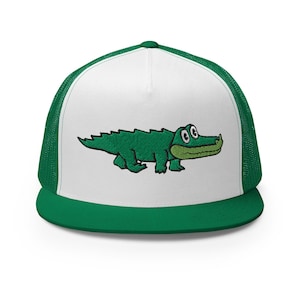 Peut inclure: Casquette de camionneur verte et blanche avec un motif d'alligator vert brodé. La casquette a un panneau avant blanc avec l'alligator, une visière verte et un dos en filet vert. L'alligator a de grands yeux et un long museau.